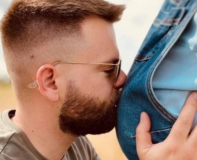 Christopher kissing pregnant Marine’s belly.